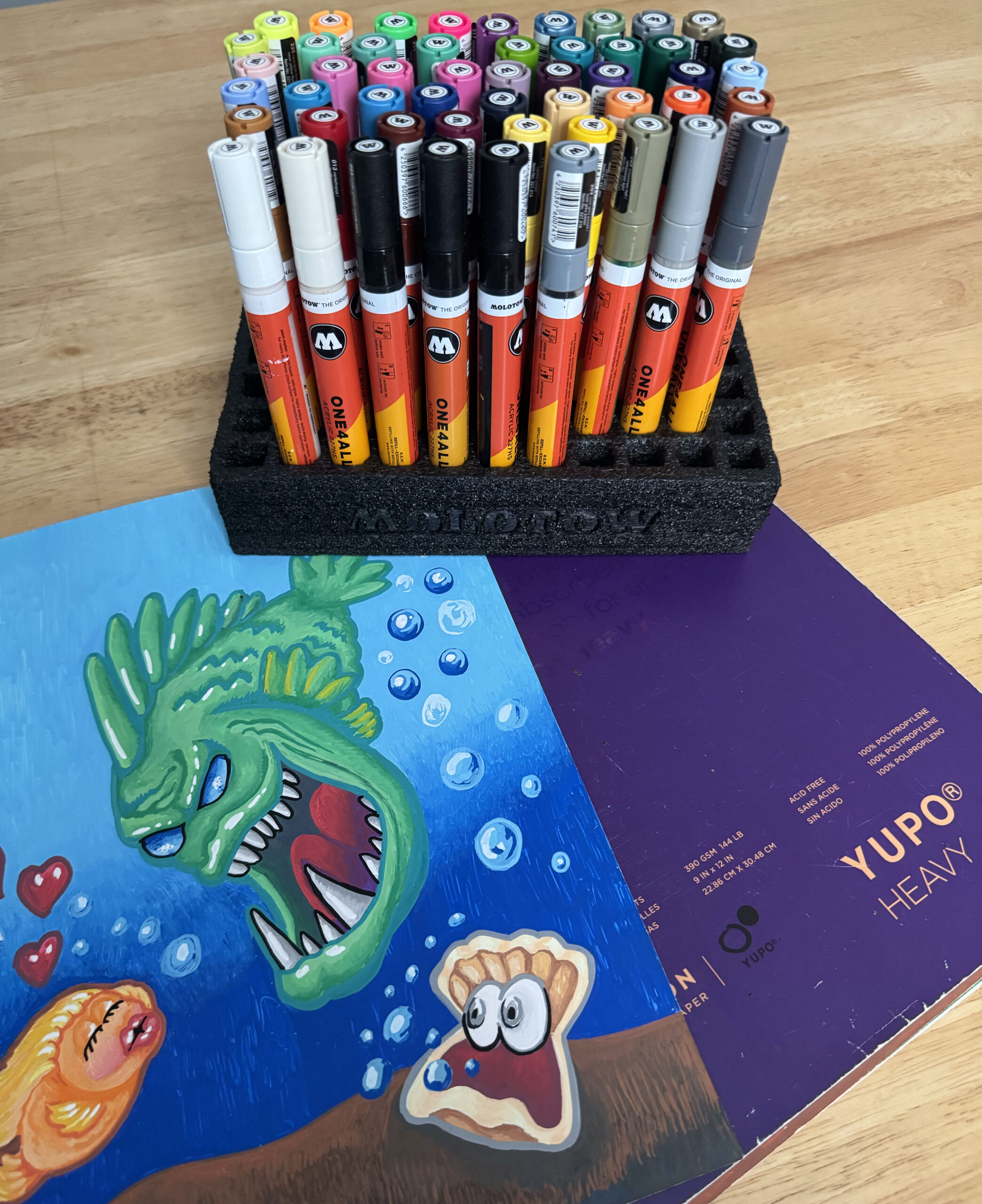 A picture of the 4mm Molotow acrylic marker set with Yupo Heavy paper and a finished illustration on the side
